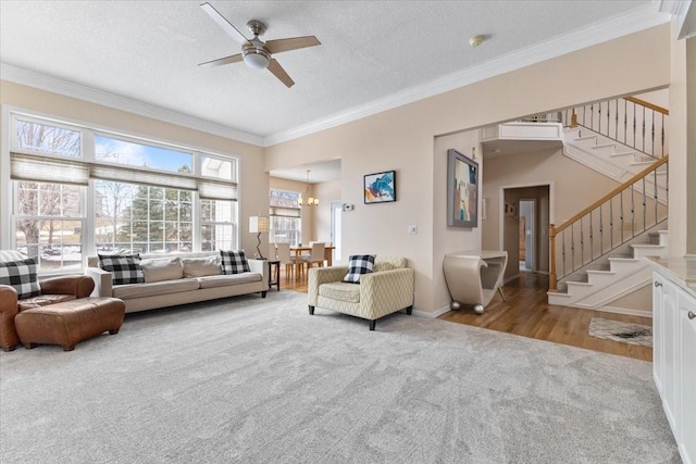 living room featuring carpet, a textured ceiling, stairway, and crown molding