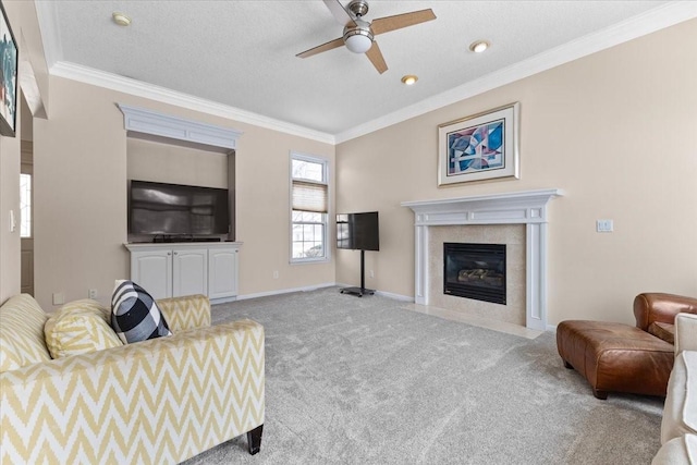 living area featuring carpet floors, baseboards, ornamental molding, and a tile fireplace