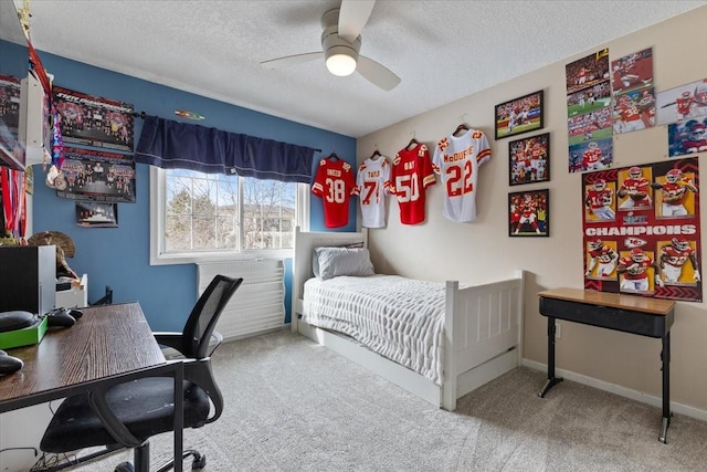 carpeted bedroom with ceiling fan, baseboards, and a textured ceiling