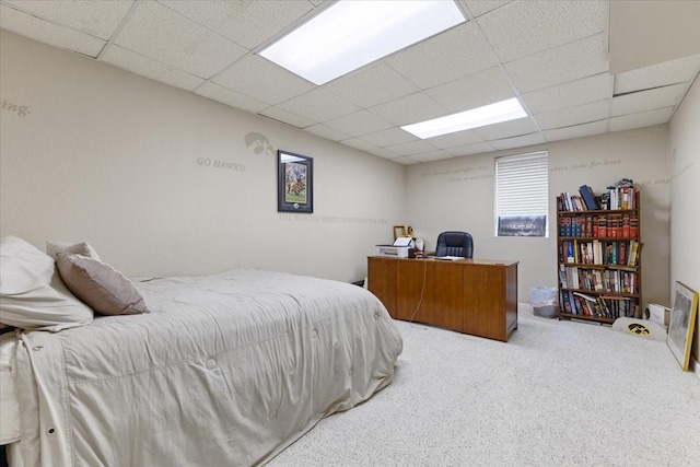 bedroom featuring a drop ceiling and carpet flooring