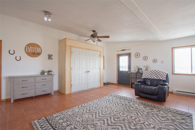 sitting room featuring baseboards, a baseboard radiator, a ceiling fan, and tile patterned floors