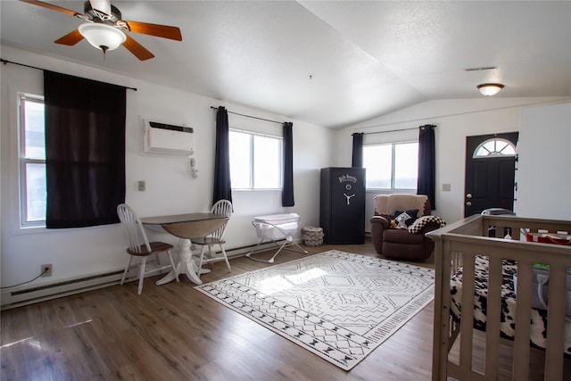 bedroom featuring multiple windows, vaulted ceiling, wood finished floors, and a wall mounted AC