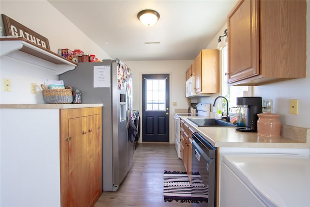 kitchen featuring light wood finished floors, open shelves, light countertops, a sink, and white appliances