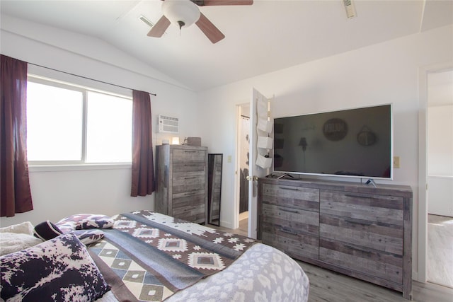 bedroom featuring lofted ceiling, ceiling fan, wood finished floors, and visible vents