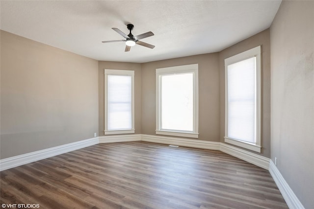 spare room featuring a ceiling fan, a textured ceiling, baseboards, and wood finished floors