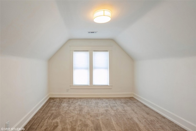 additional living space featuring lofted ceiling, carpet, baseboards, and visible vents