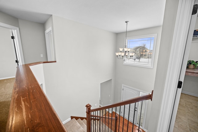 stairway with baseboards and a notable chandelier