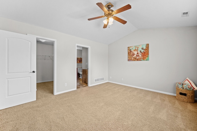 unfurnished bedroom with visible vents, carpet flooring, vaulted ceiling, and a spacious closet