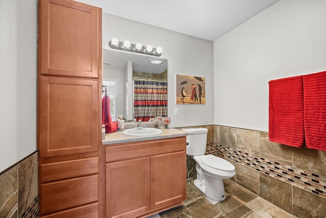 full bathroom featuring toilet, a wainscoted wall, vanity, tile walls, and a shower with curtain