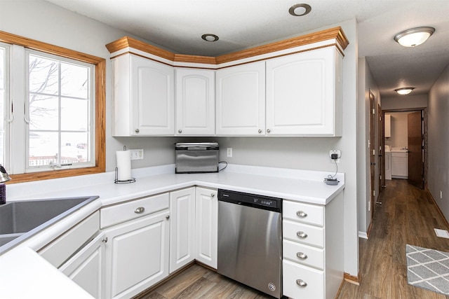 kitchen with wood finished floors, stainless steel dishwasher, a sink, and white cabinets