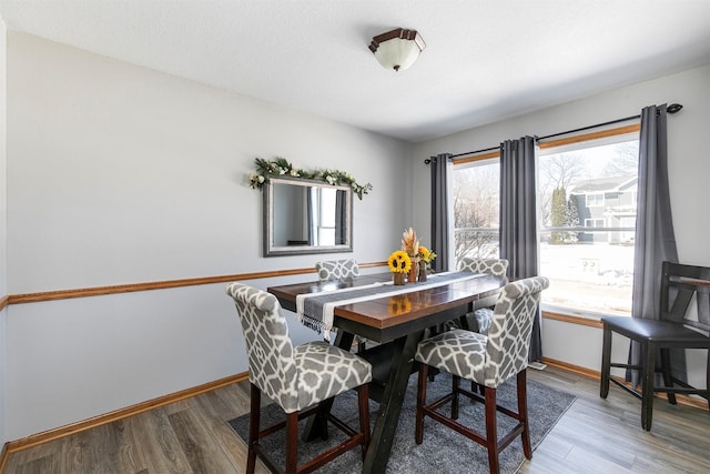 dining room featuring plenty of natural light, baseboards, and wood finished floors