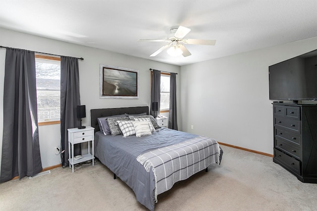 bedroom with baseboards, multiple windows, and light colored carpet