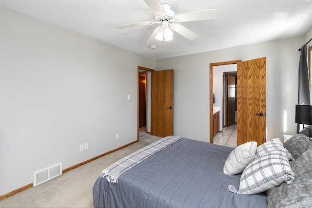 bedroom featuring connected bathroom, light colored carpet, visible vents, and baseboards