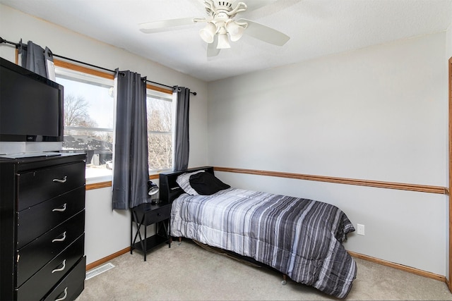 bedroom with visible vents, baseboards, a ceiling fan, and light colored carpet