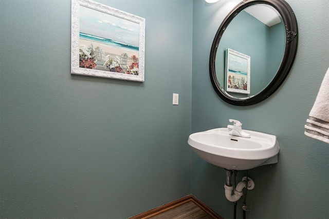 bathroom featuring a sink, wood finished floors, and baseboards