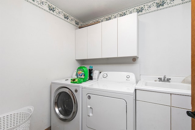 laundry room featuring cabinet space, a sink, and independent washer and dryer