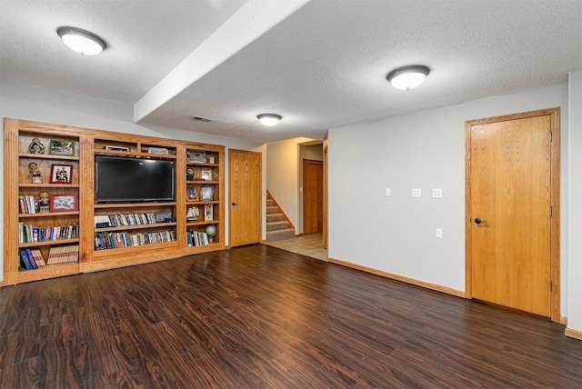 interior space featuring stairs, a textured ceiling, wood finished floors, and baseboards