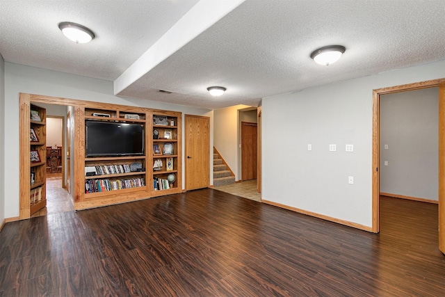 interior space featuring a textured ceiling, stairway, wood finished floors, and baseboards