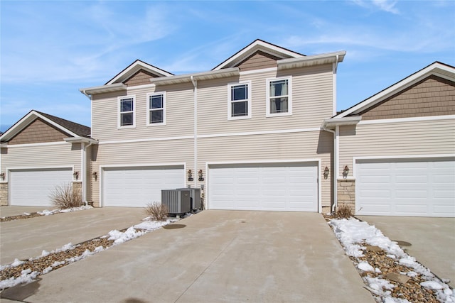 view of front of home featuring cooling unit, driveway, and an attached garage