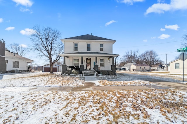 american foursquare style home featuring a porch and an outbuilding