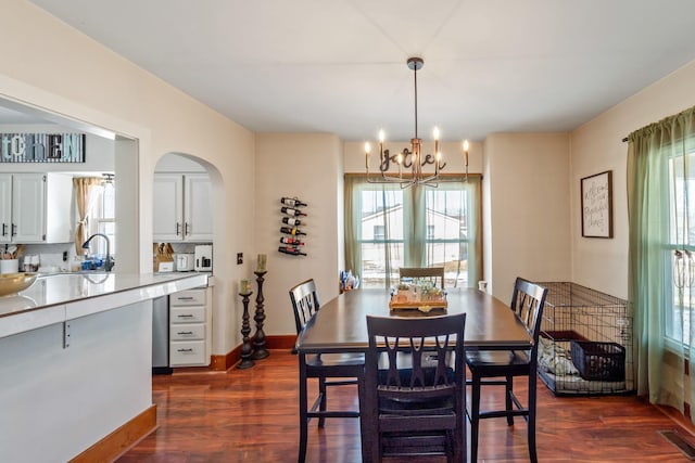 dining area with an inviting chandelier, plenty of natural light, visible vents, and dark wood-style flooring