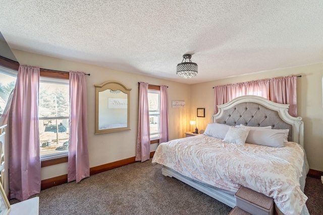 bedroom with carpet, multiple windows, baseboards, and a textured ceiling