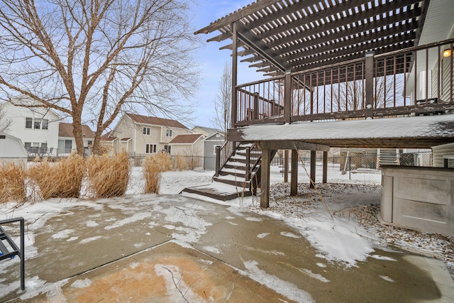 snow covered patio with stairs, fence, a pergola, and a residential view