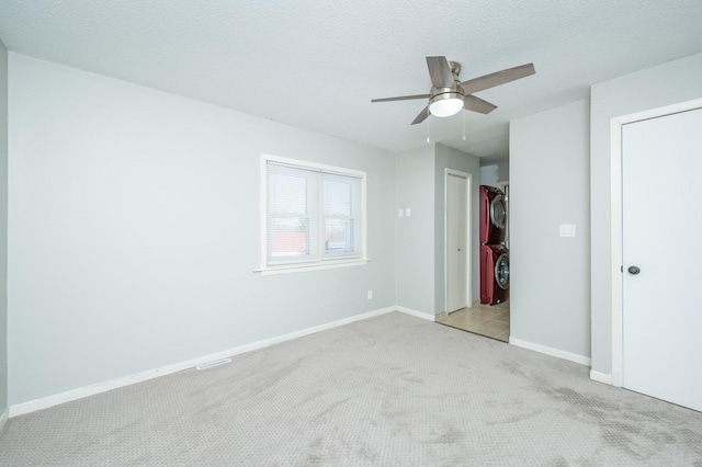 unfurnished bedroom with a textured ceiling, carpet floors, ceiling fan, and baseboards