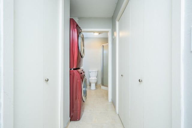 hallway featuring stacked washer and dryer and light tile patterned floors