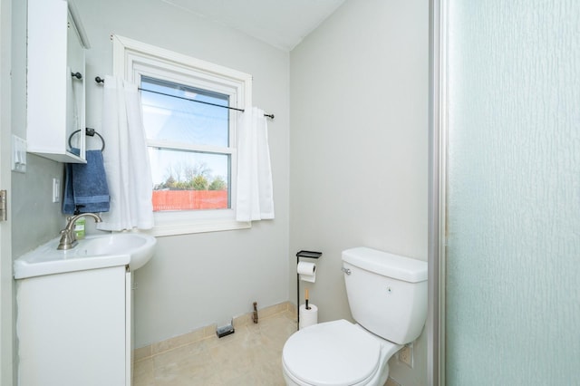 bathroom featuring a sink, toilet, and tile patterned floors