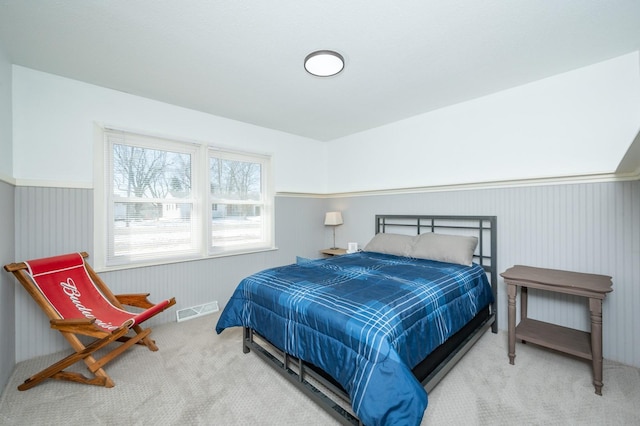 bedroom featuring carpet floors, wainscoting, and visible vents