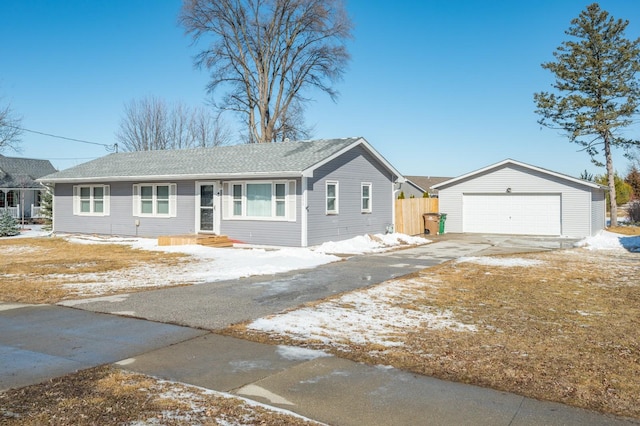 ranch-style house featuring driveway, a detached garage, an outdoor structure, and fence