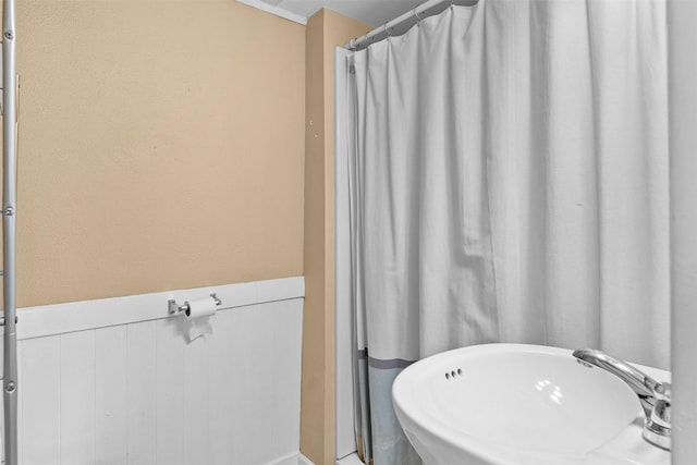 bathroom featuring a wainscoted wall and a sink