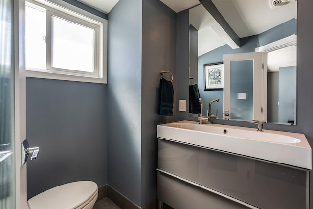 bathroom featuring toilet, vaulted ceiling, and vanity