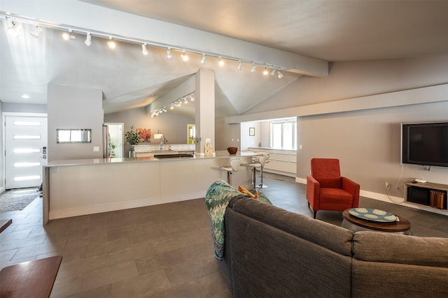 living room featuring lofted ceiling with beams and baseboards