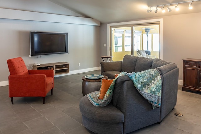 living room featuring track lighting, lofted ceiling, and baseboards