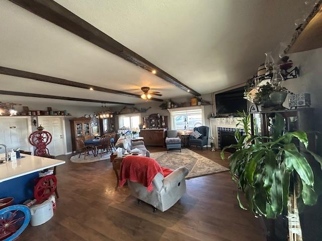 living room with a fireplace, wood finished floors, beam ceiling, and a notable chandelier