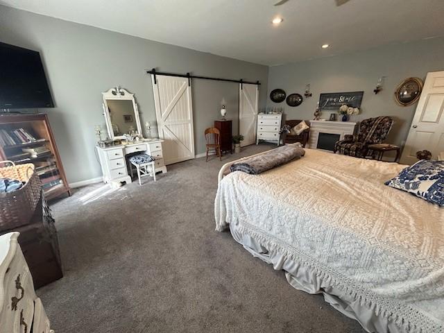 bedroom featuring carpet floors, recessed lighting, baseboards, and a barn door