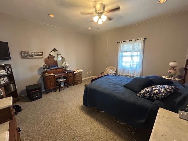 carpeted bedroom with a ceiling fan and baseboards