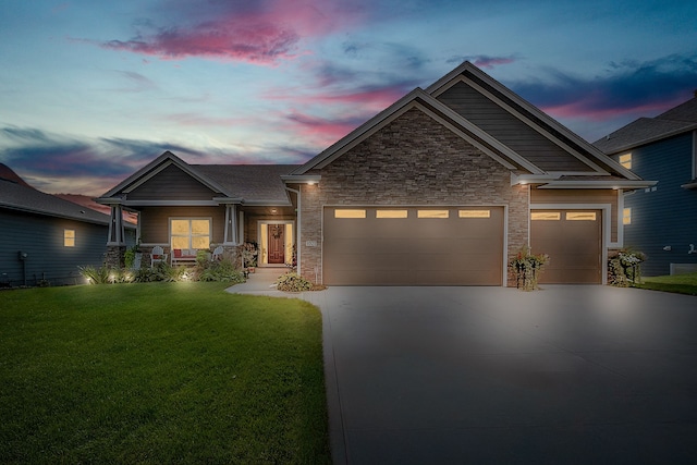 craftsman-style house with concrete driveway, an attached garage, a front yard, and stone siding