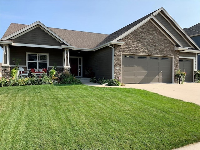 craftsman house with an attached garage, covered porch, driveway, stone siding, and a front lawn