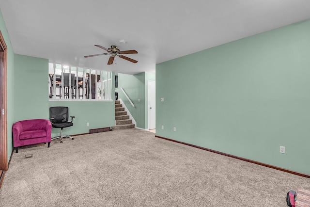 living area with ceiling fan, stairs, baseboards, and carpet flooring