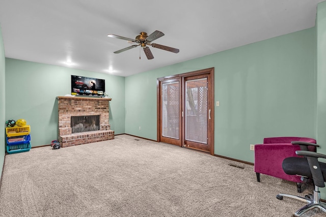 carpeted living room with a brick fireplace, visible vents, ceiling fan, and baseboards