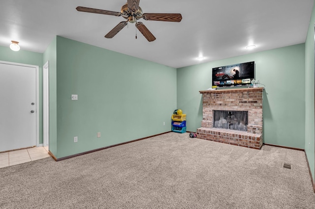 unfurnished living room featuring baseboards, a ceiling fan, tile patterned flooring, carpet flooring, and a brick fireplace