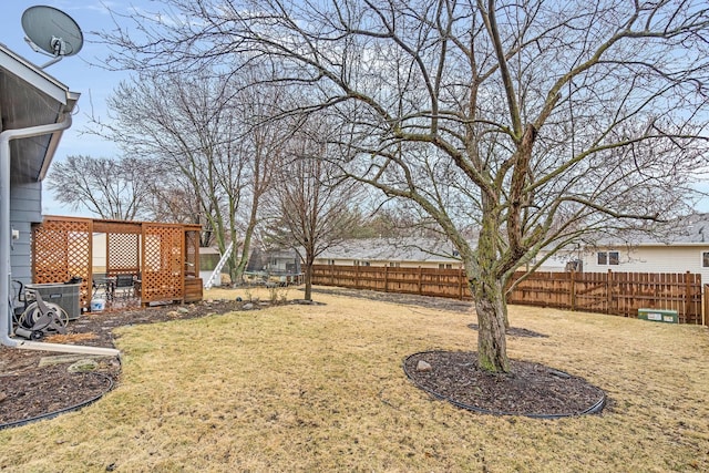 view of yard with central air condition unit and fence