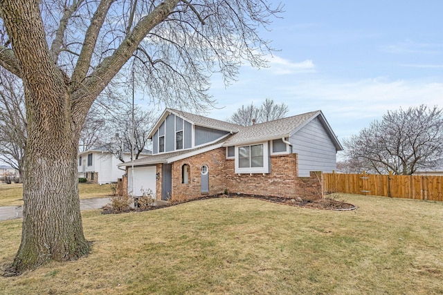 view of home's exterior with brick siding, a shingled roof, fence, a yard, and driveway