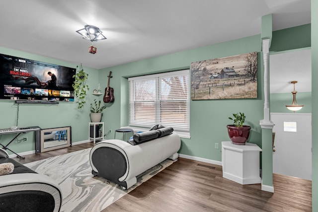 bedroom featuring visible vents, baseboards, and wood finished floors