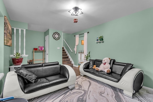 living area featuring wood finished floors, baseboards, and stairs