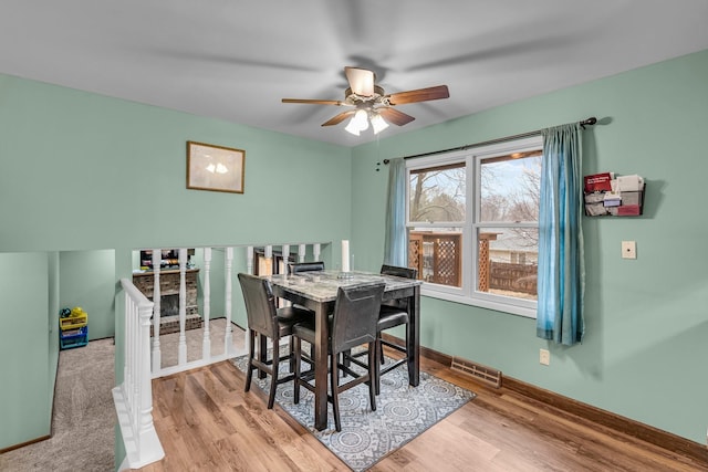 dining room featuring ceiling fan, wood finished floors, visible vents, and baseboards