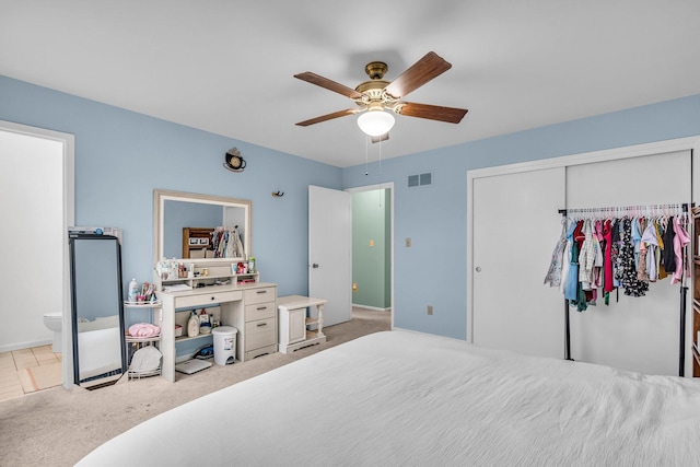 carpeted bedroom featuring a closet, visible vents, connected bathroom, and ceiling fan